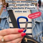Un mousqueton fixé à un sac de voyage sur une plage.